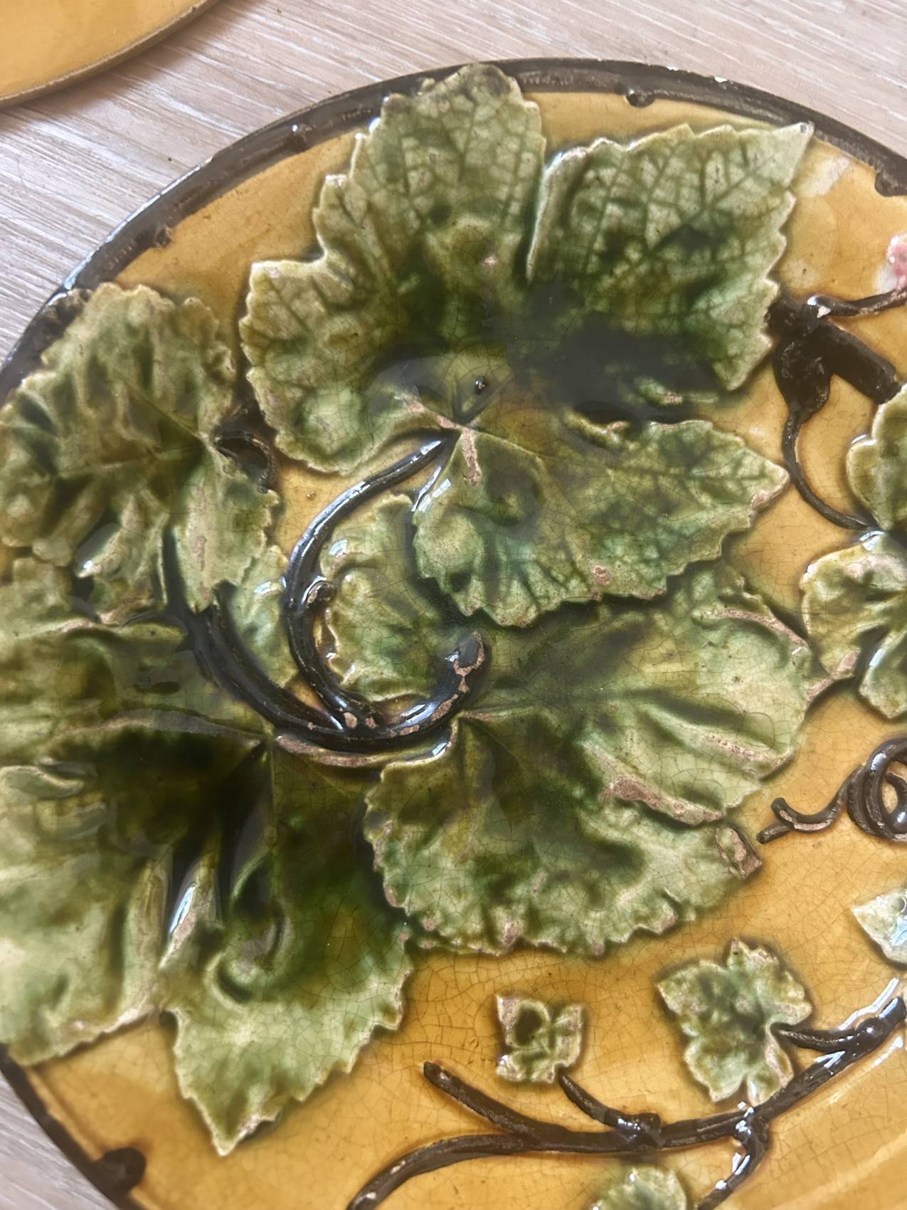 Four antique dessert plates in majolica with vine decoration.