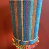 "Stoneware Bottle Lamp" with a multicoloured blue lampshade handwoven in India.