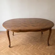 Round extendable dining table in Louis XV style made of wood.