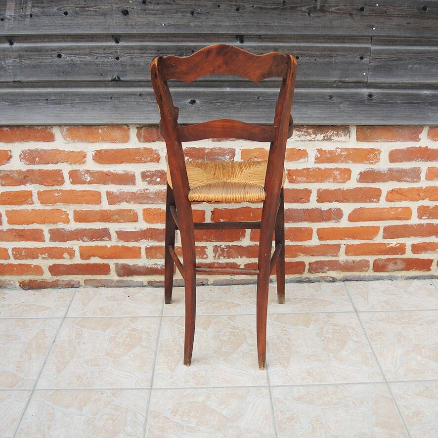 Old wooden high chair for children with straw.