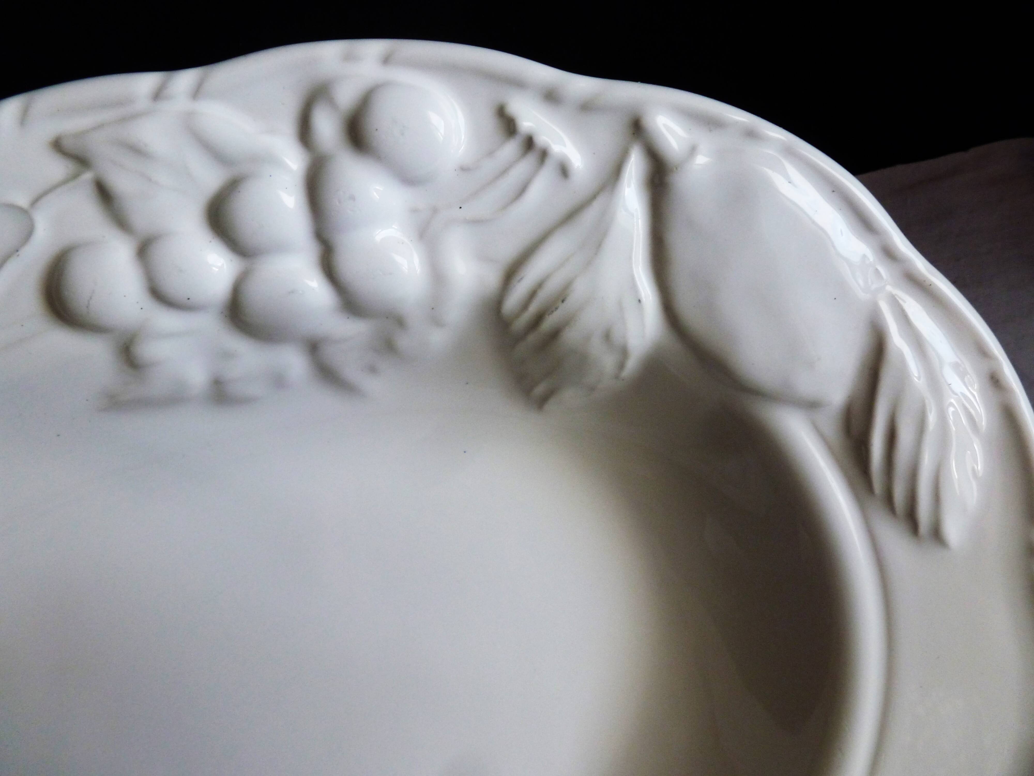 Oval white vegetable dish, an antique tableware piece in barbotine earthenware.