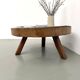 Brutalist coffee table in solid teak, monolithic slab, tripod base.
