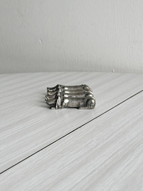 Antique metal knife rest in the shape of a dog.