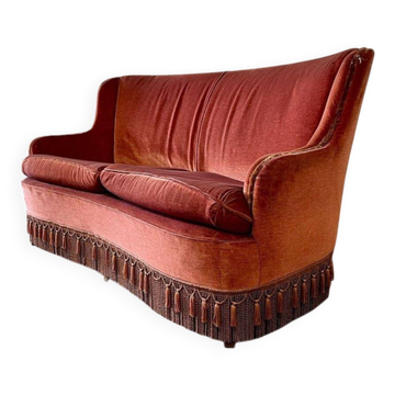Vintage two-seater armchair in powder pink velvet with fringes.