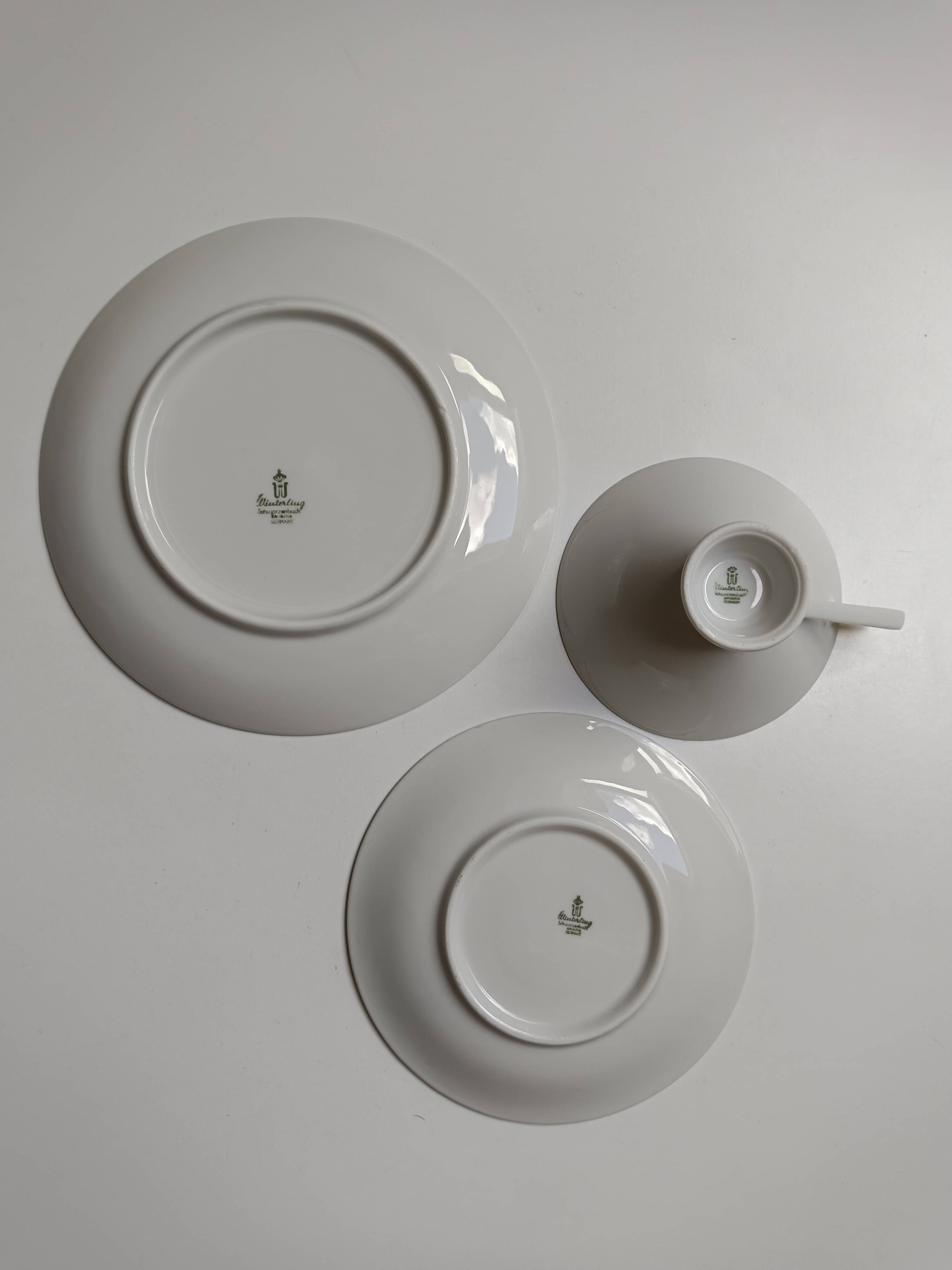 Solitaire tea cup, saucer, and dessert plate in white and gold.