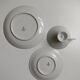 Solitaire tea cup, saucer, and dessert plate in white and gold.