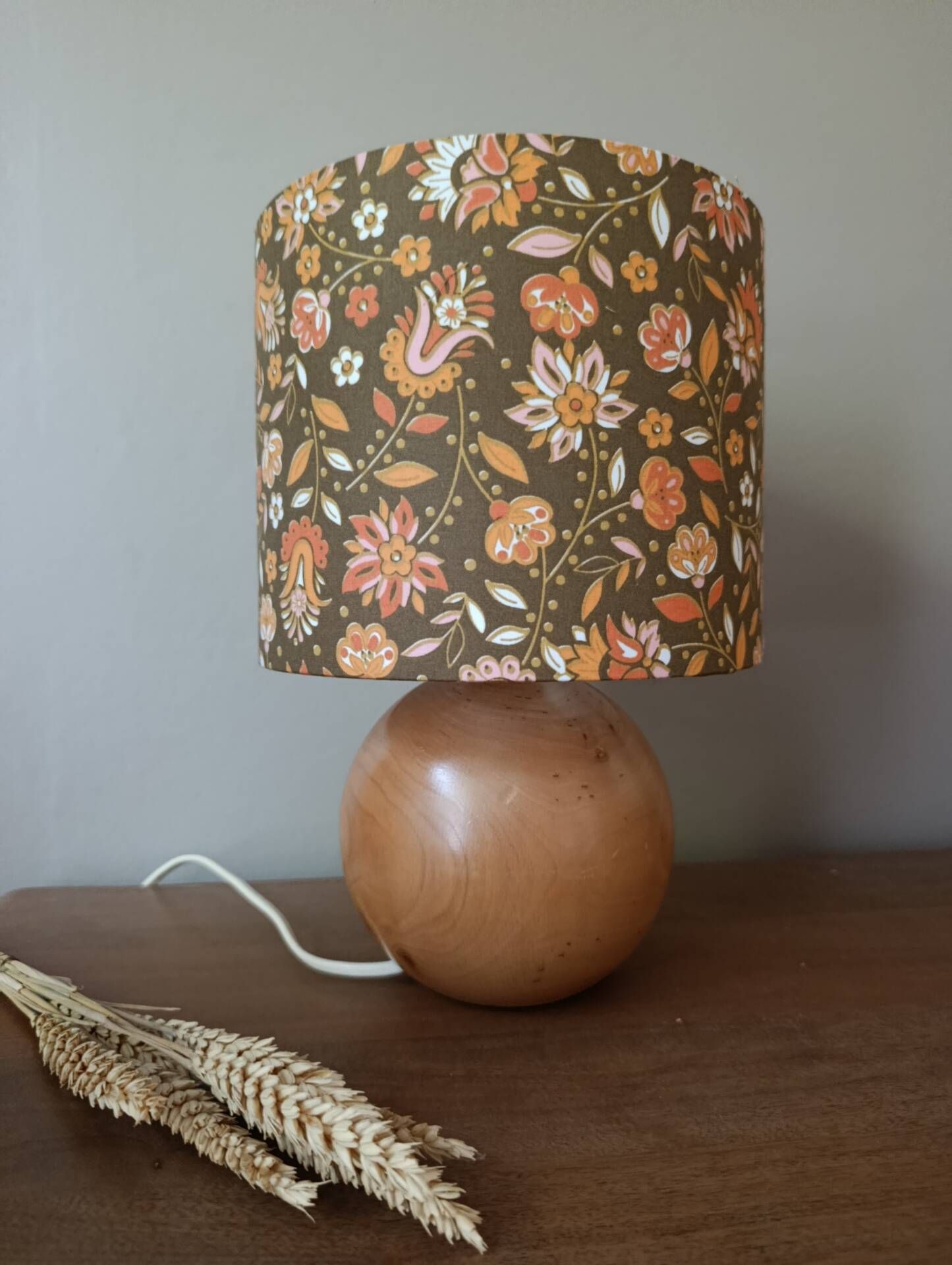 Table lamp with a wooden ball base, floral print in bohemian style.