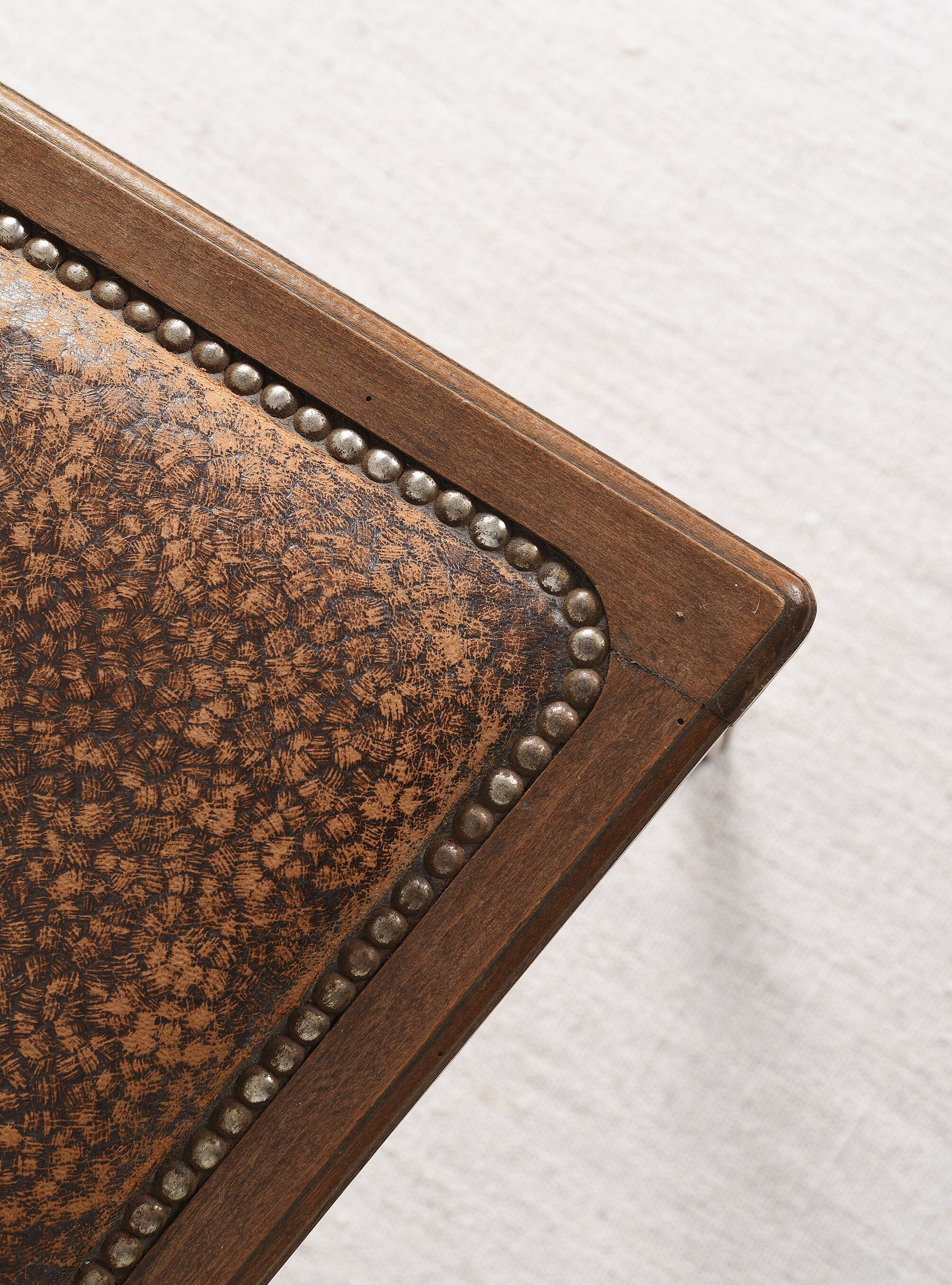 Art Deco style chair in carved wood and leather.