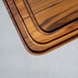Trio of rounded rectangular trays or cups in monoxyl teak L:35