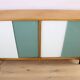 A vintage mid-century bookshelf/sideboard with green and white sliding door