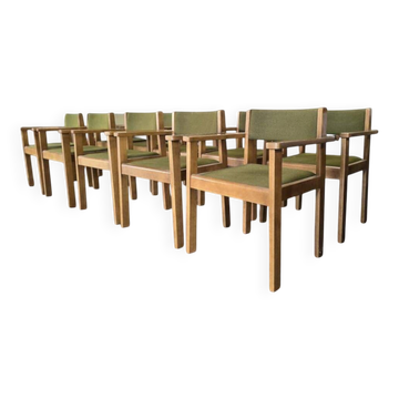 Vintage wooden chair with olive green seat and armrests.