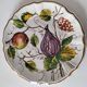 Set of three earthenware plates from Bassano, hand-painted with fruit and flower designs.