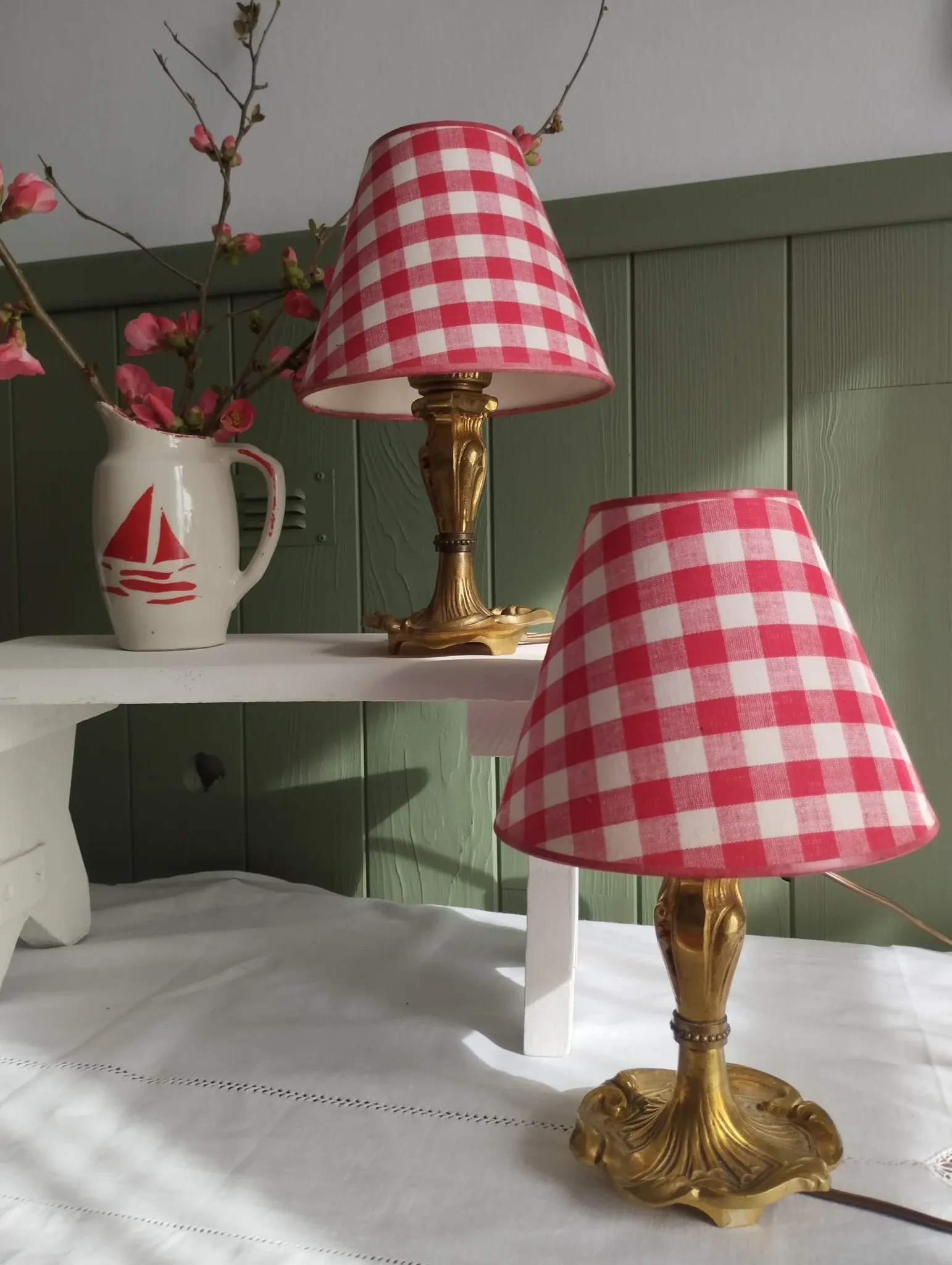 Pair of small lamps in gilded bronze by Petitot and red gingham lampshades.
