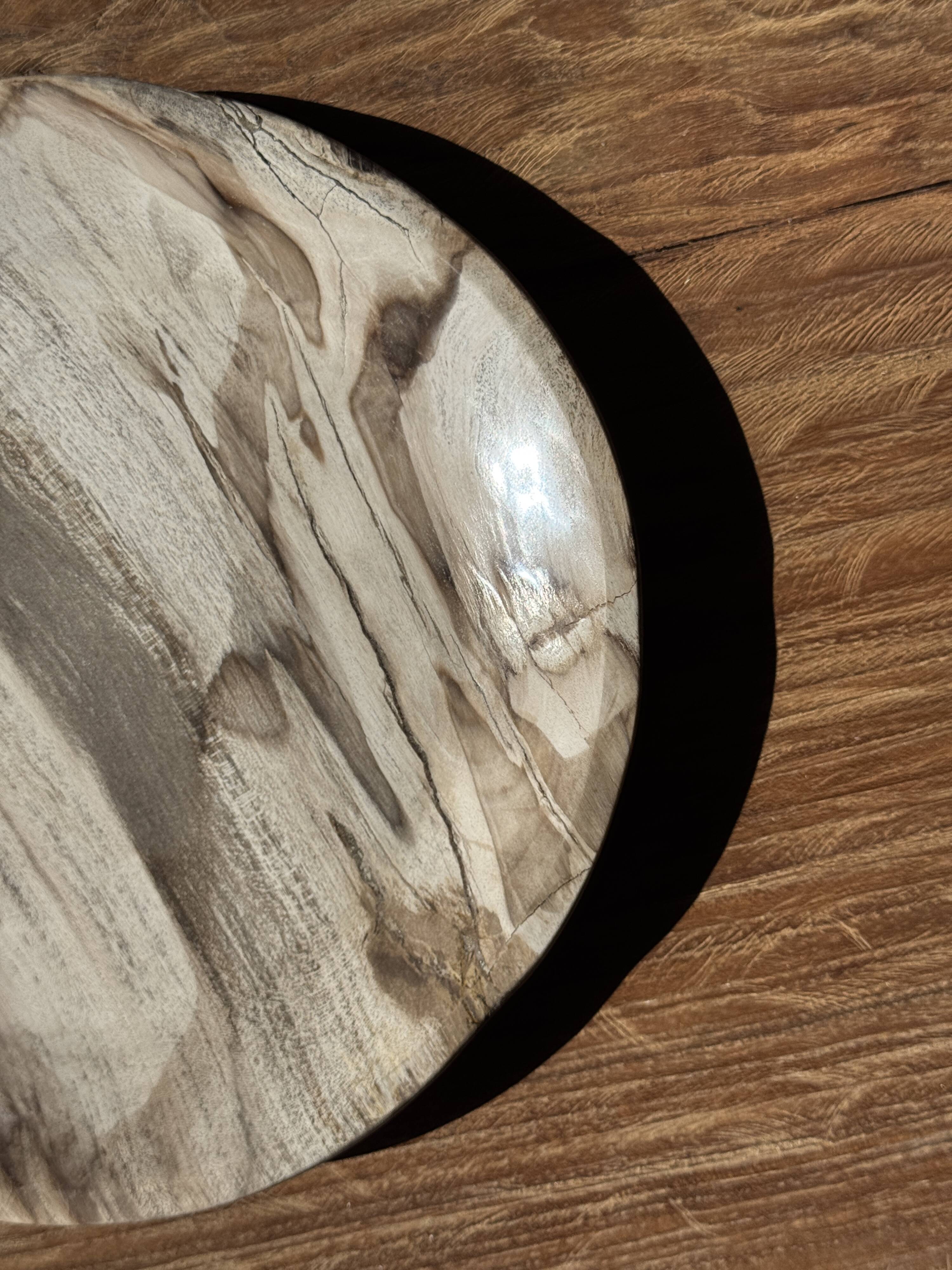 Tray, circular dish or plate made of white striped grey petrified wood.