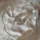 Standing molded glass cup depicting a flower