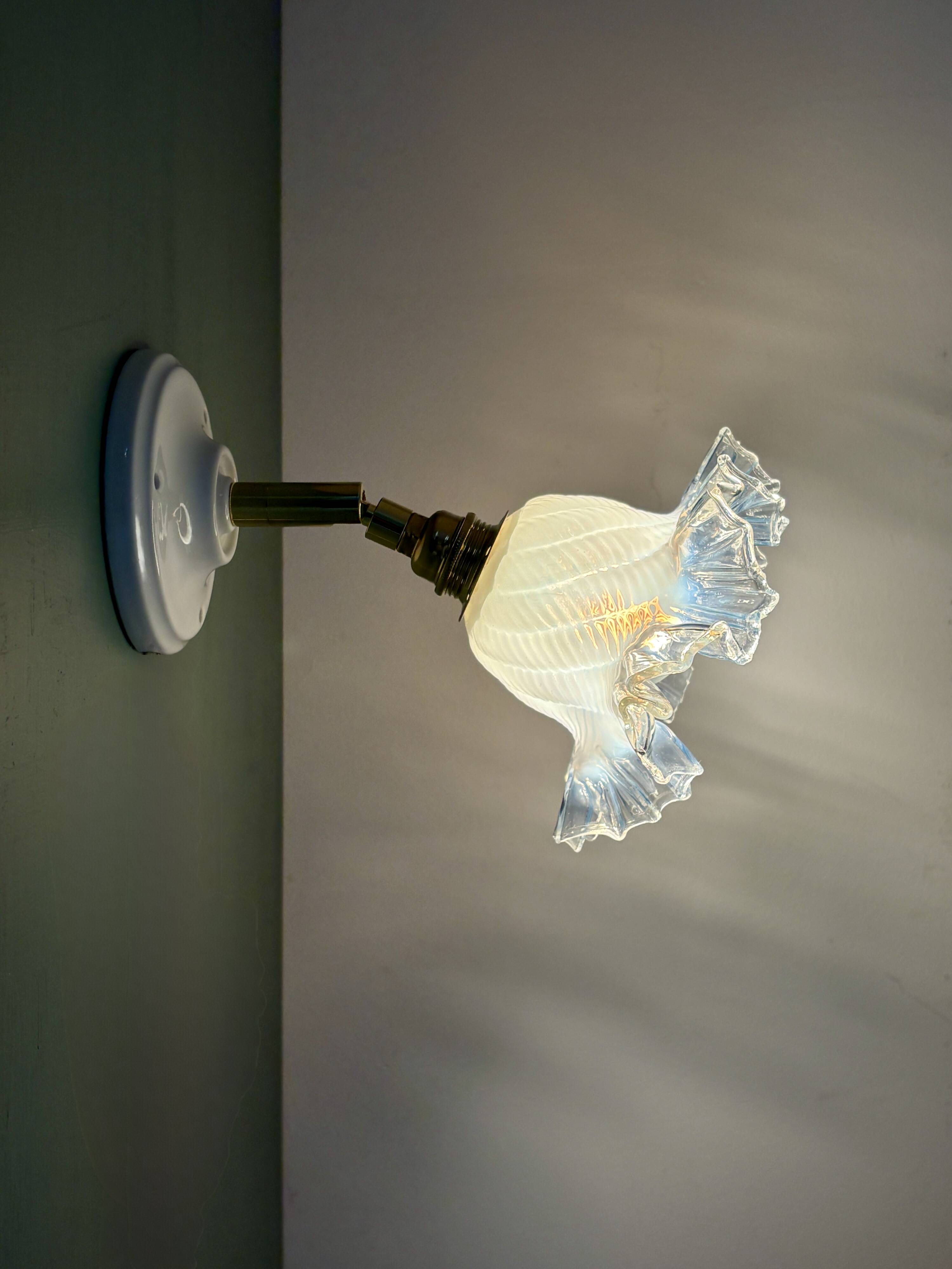 Vintage tulip glass wall light in transparent, slightly pearlescent white.