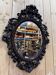 Oval mirror in carved wood with dragon heads.