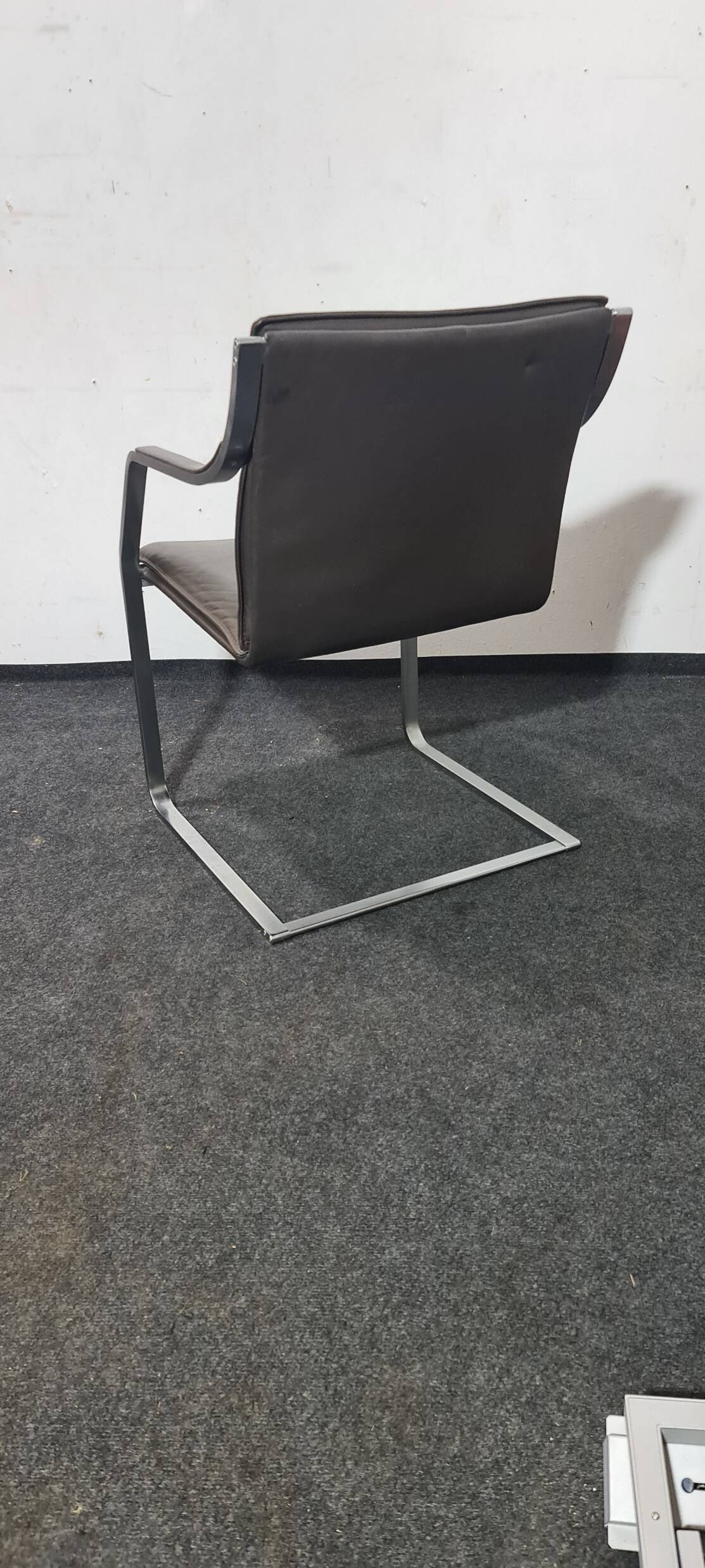 One of two vintage Leather and metal arm chairs.