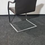 One of two vintage Leather and metal arm chairs.