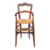 Old wooden high chair for children with straw.