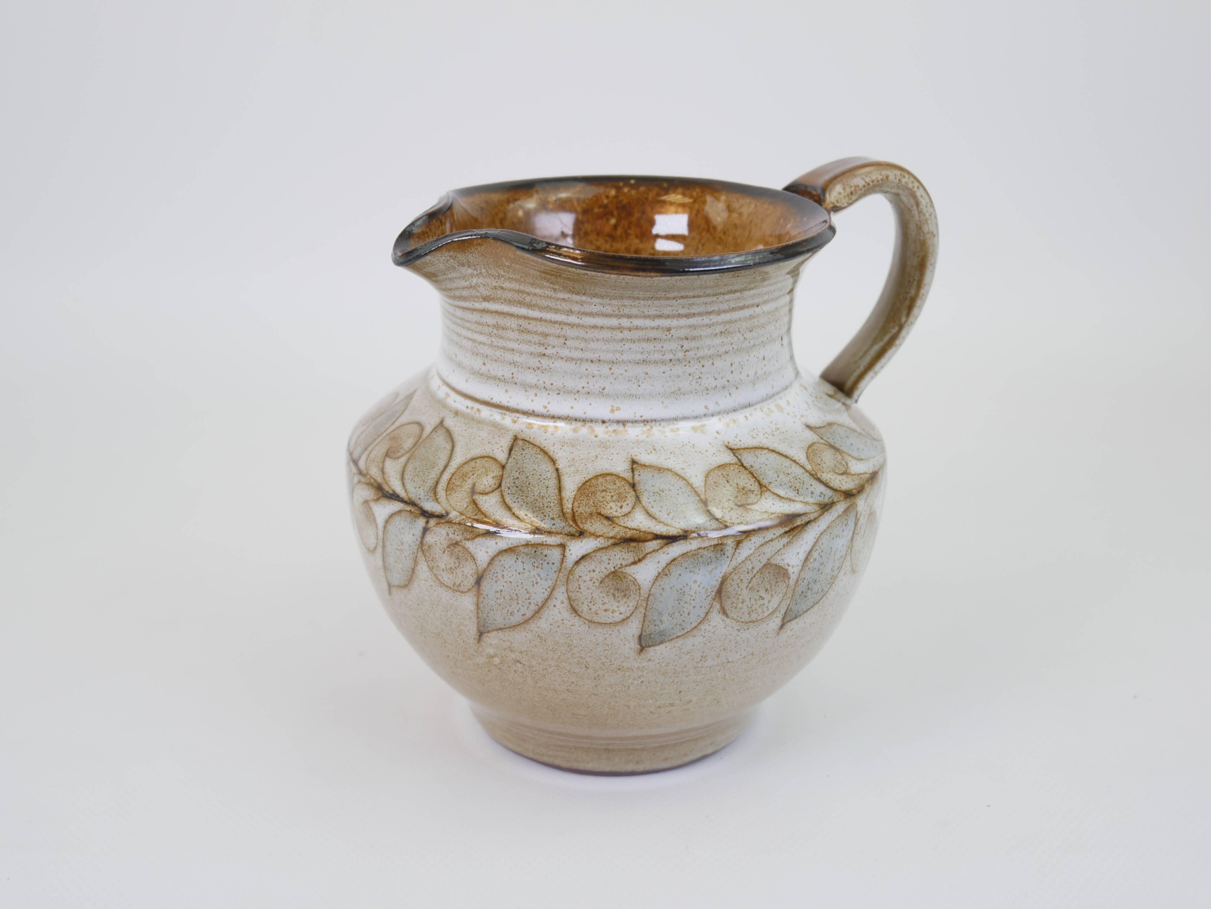 Glazed ceramic jug with plant decoration
