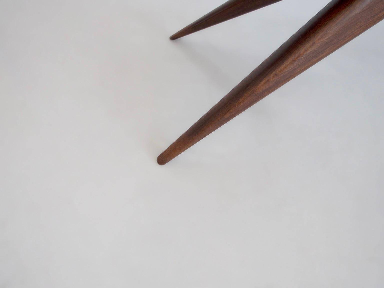 Dining table with a wooden frame and tinted glass top.