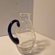 Glass carafe with wavy body and blue handle