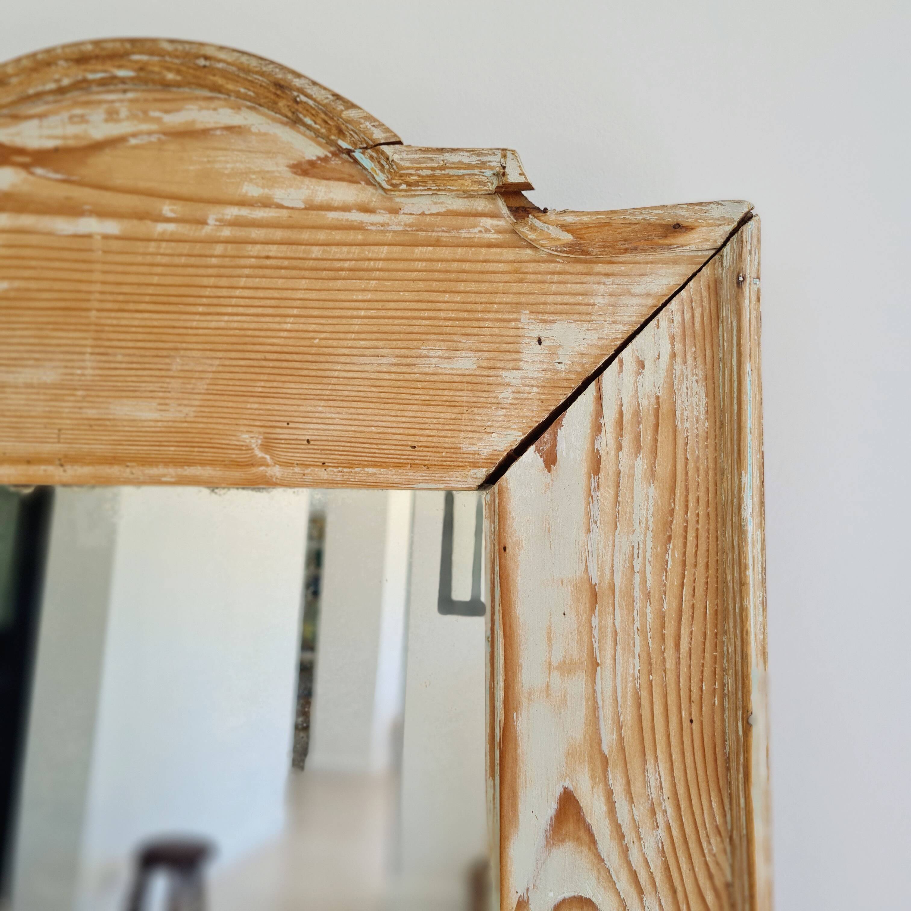 Antique mirror in raw wood with a patina and pediment.