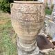 Large Cretan jar in terracotta with three handles on a stone base.