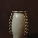White glazed stoneware vase decorated with raised ribbons.