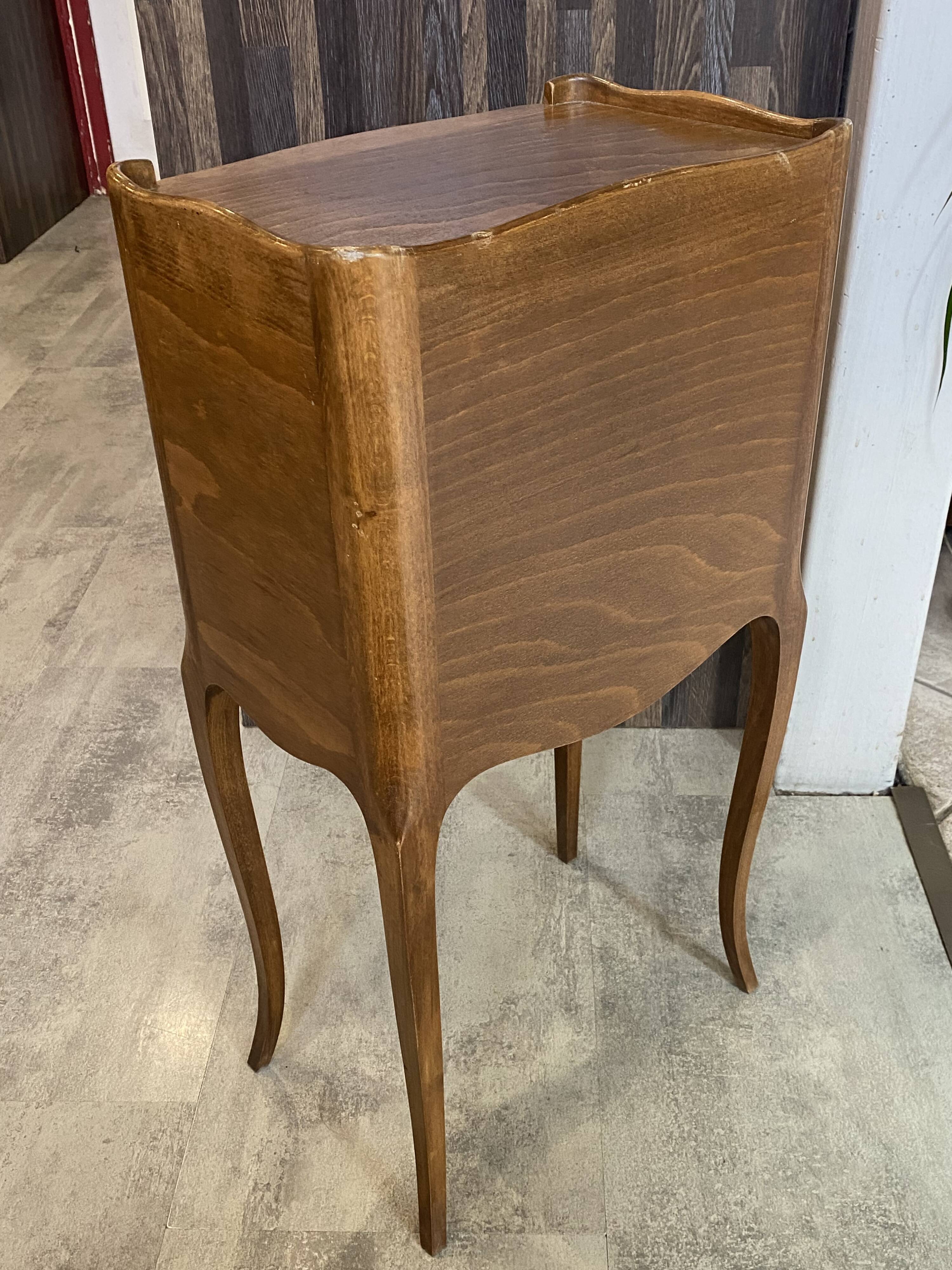 A bedside table with a drawer and a niche in Louis XV style.
