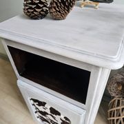 Two solid wood bedside tables with calfskin decoration.