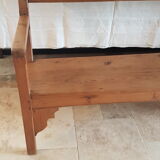 Church bench in fir tree with armrests