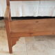 Church bench in fir tree with armrests