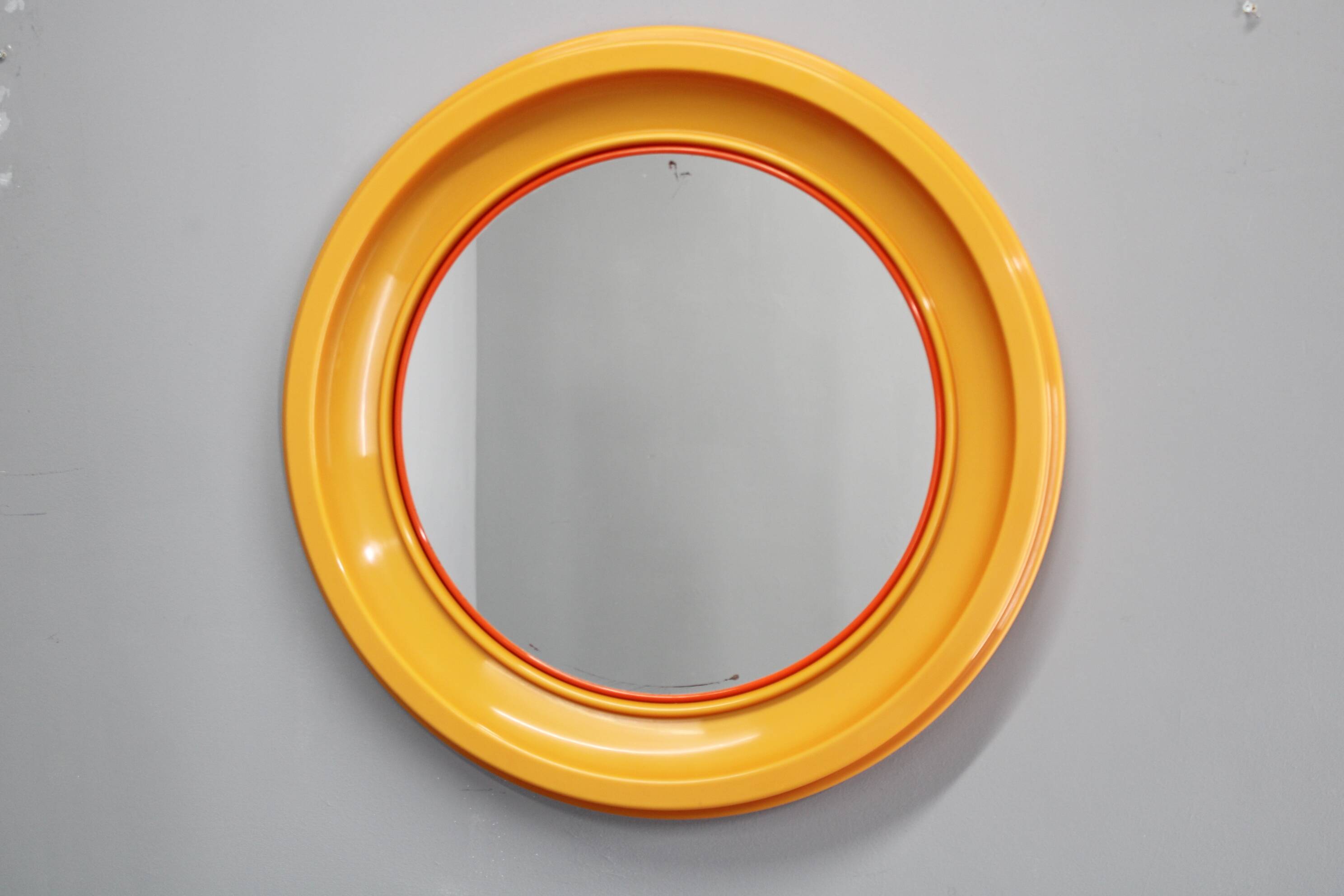 Miroir rond italien des années 1970 de la marque Salc, avec cadre en plastique jaune orangé.