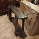 Small, very old, brutalist workbench equipped with a period workshop lamp