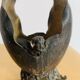 Antique decorative cup in hammered metal with putto design.