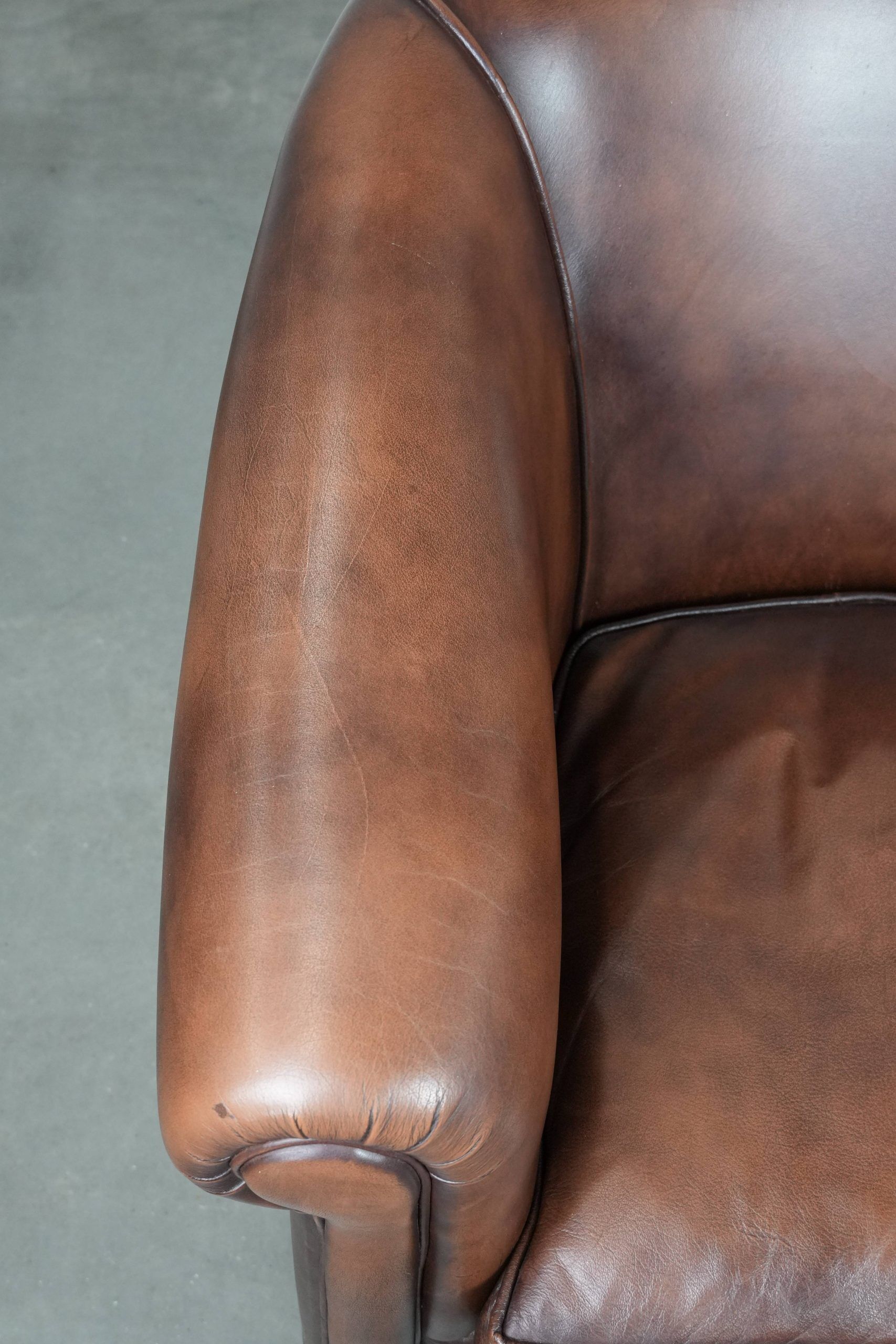 Great luxurious brown cowhide club armchair with matching piping