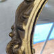 Round wooden mirror in golden colour.