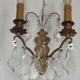 Pair of French antique brass double wall lights with assorted crystals.