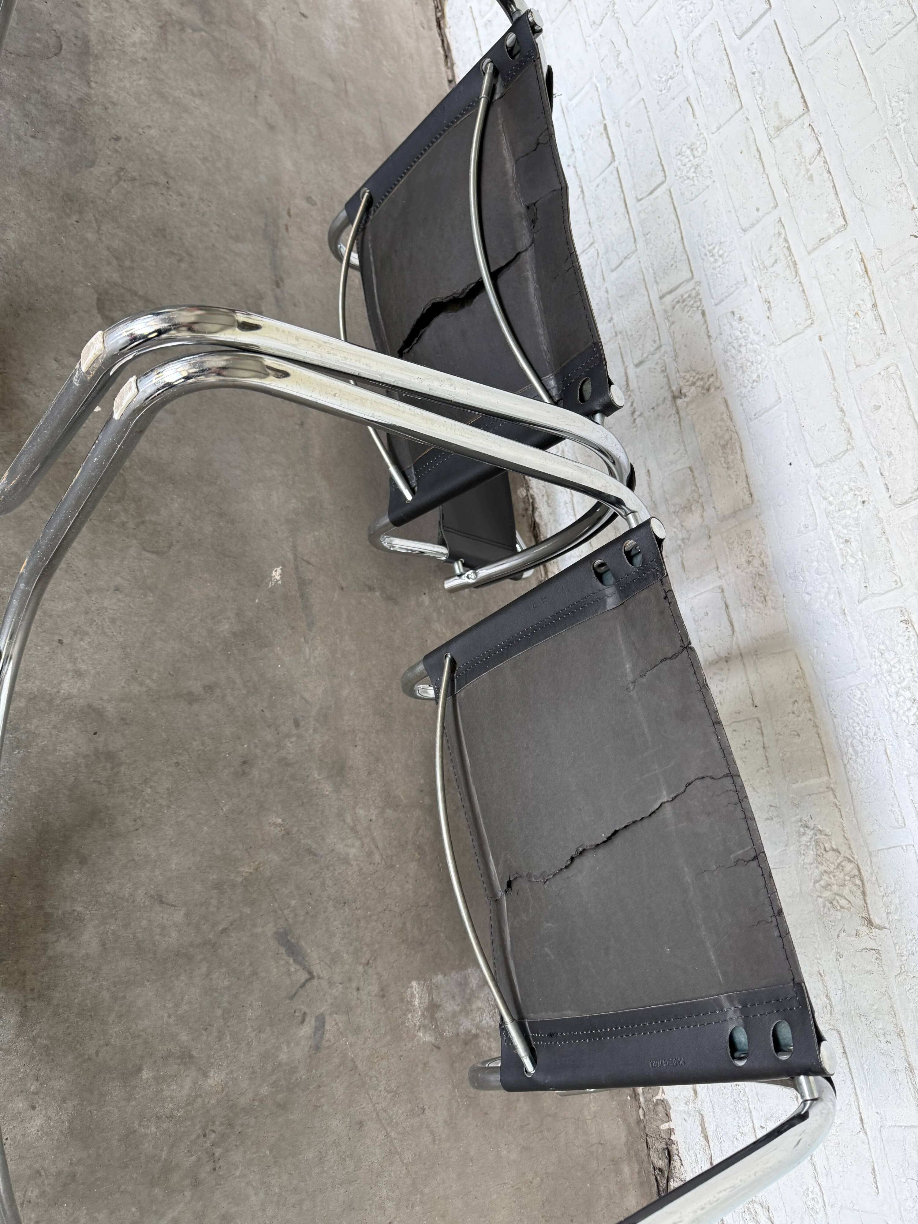Vintage cantilever chairs in black saddle leather and chrome.