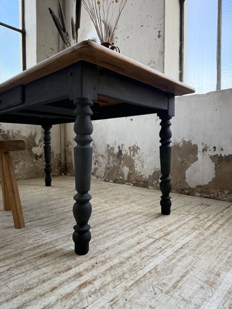 Oak farmhouse table with turned black legs.