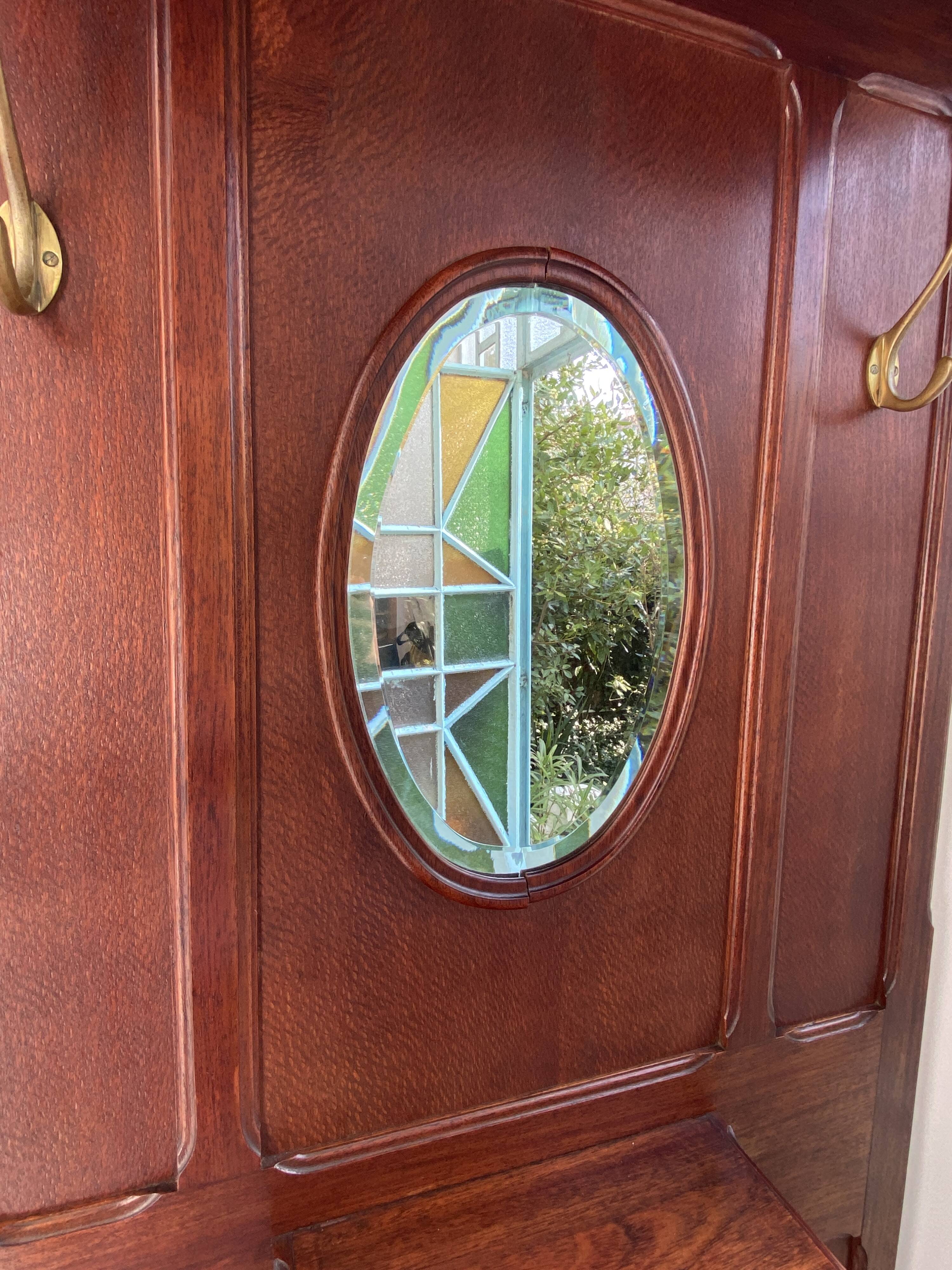 Antique wooden coat rack with mirror and shelf.