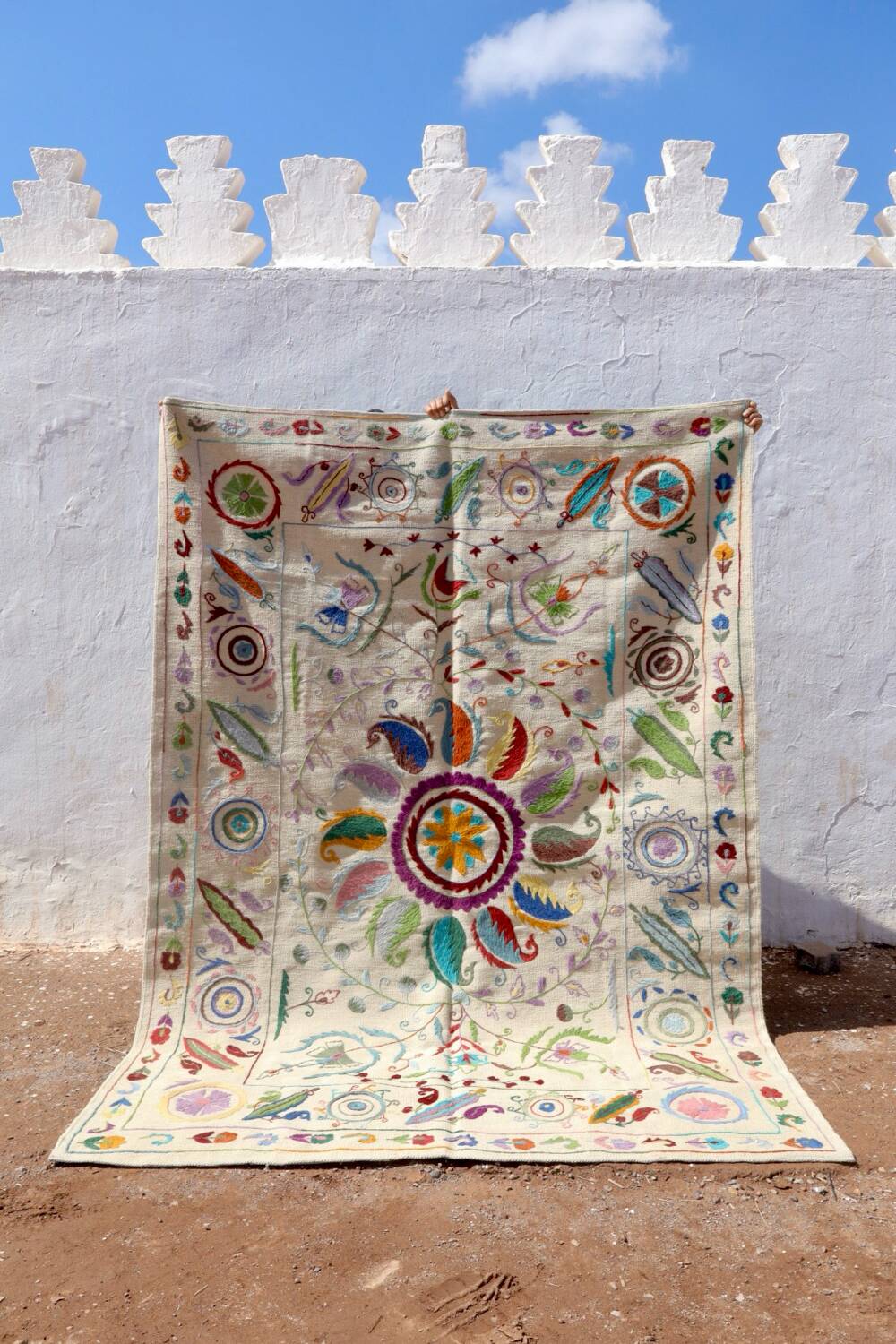 White suzani kilim rug with embroidered multi-colored patterns