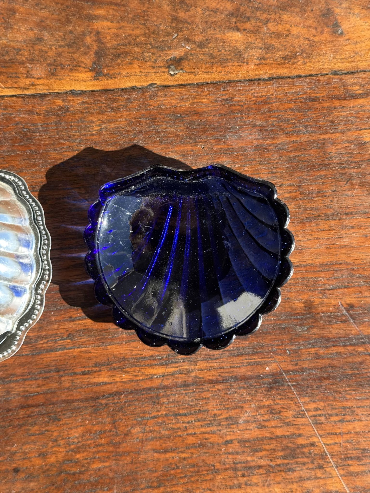 Vintage silver-plated shell butter dish with blue bowl.