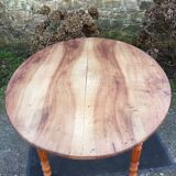 Table ovale ancienne en cerisier à piétement parapluie.