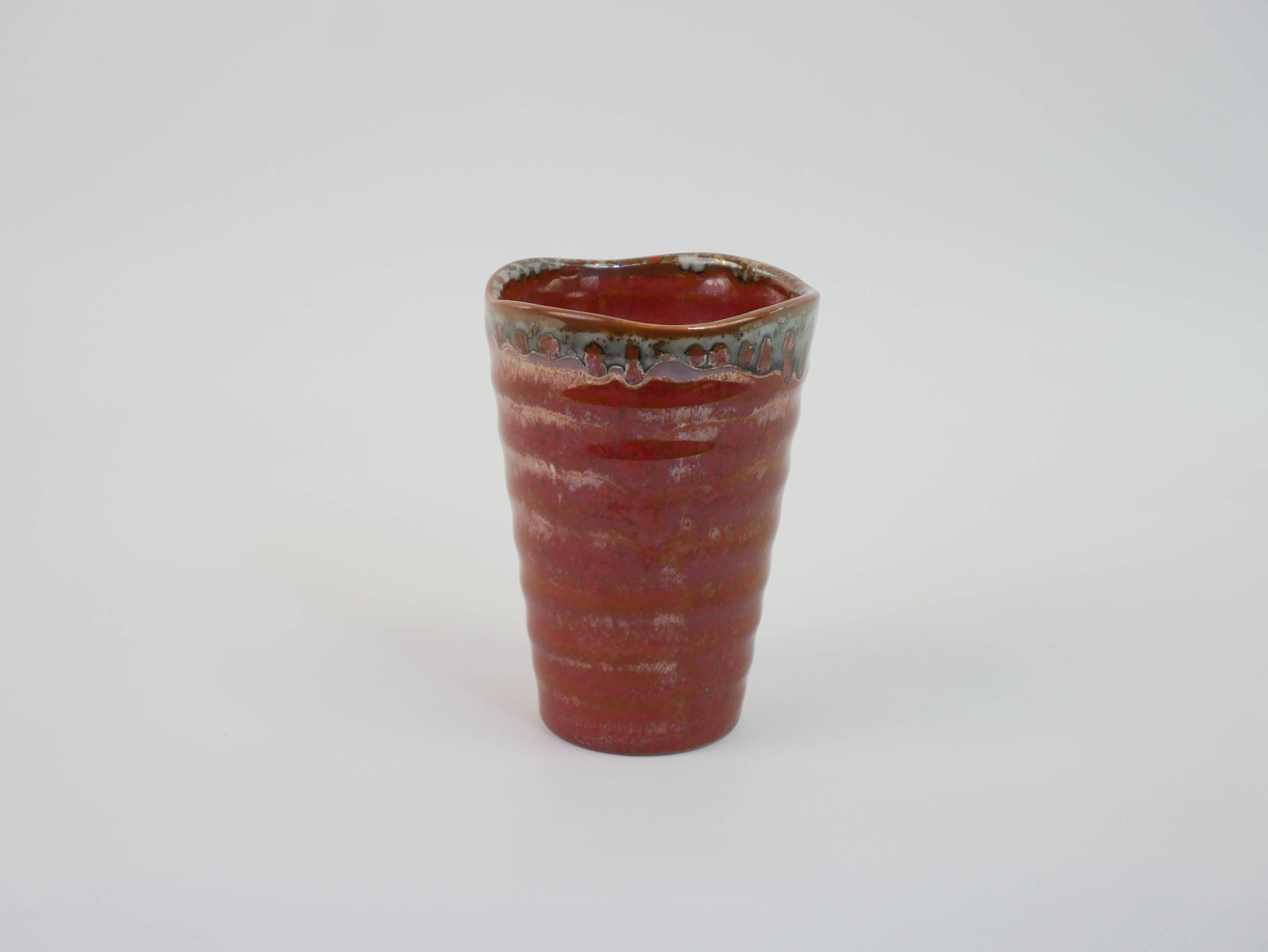 Small orange glazed ceramic cup