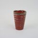 Small orange glazed ceramic cup
