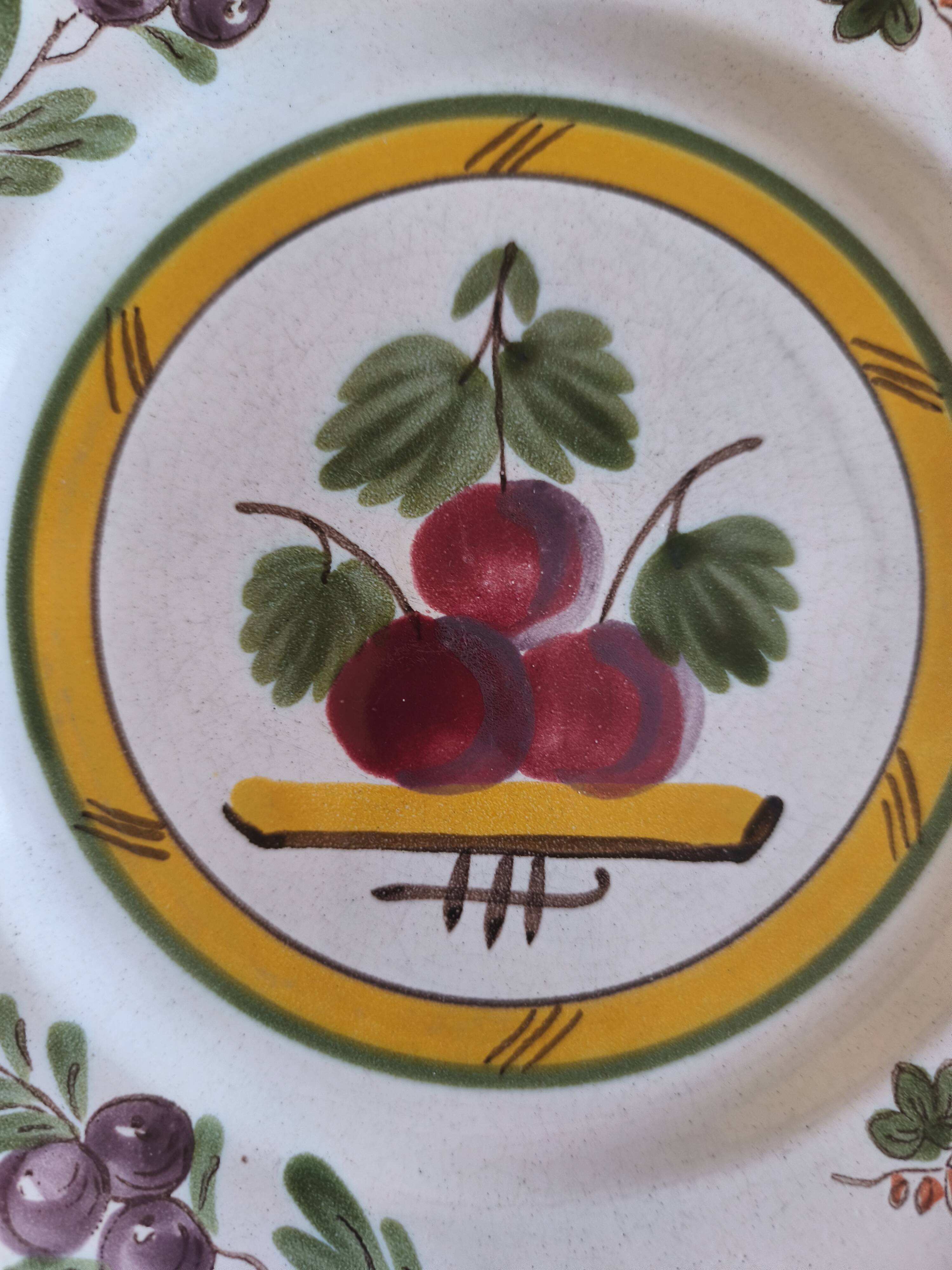 Two earthenware plates with fruits, pears and plums.