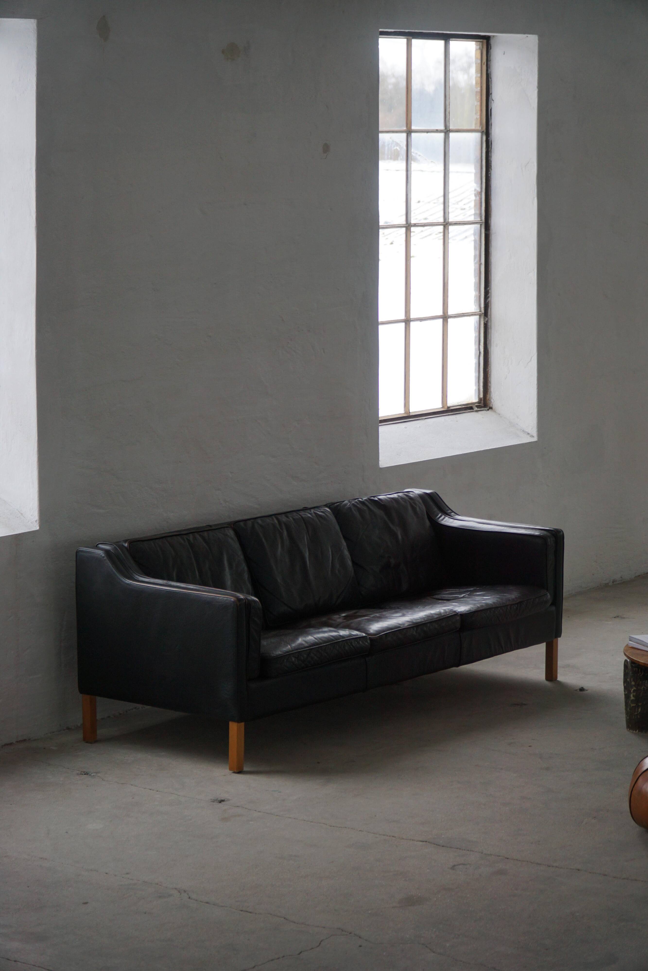 Three-seater canapé by Mogens Hansen, mid-century, in patinated black leather and solid beech.